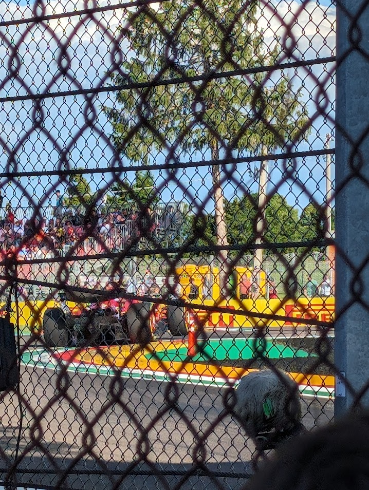 GA view at the entrance to the Gresini china with grandstands in the background and a Ferrari climbing curbs.