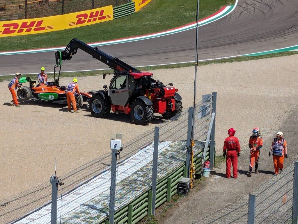 F2 driver, Dennis Hauger, exits the Tosa corner gravel trap on foot after getting beached during an accident.