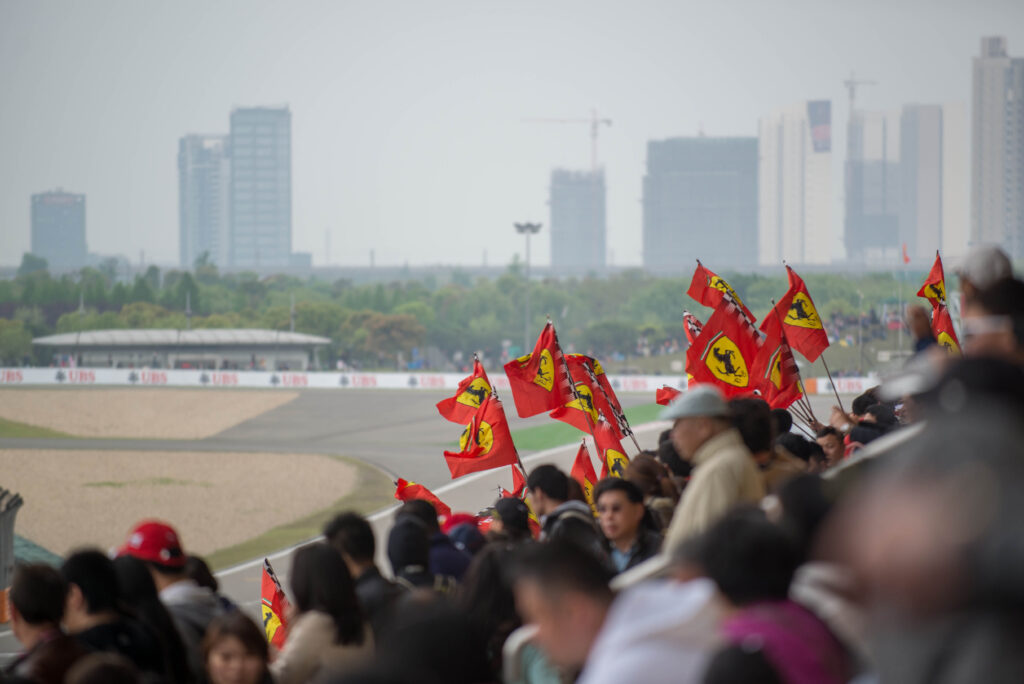 Shanghai main straight grandstands with Ferrari flags in focus.