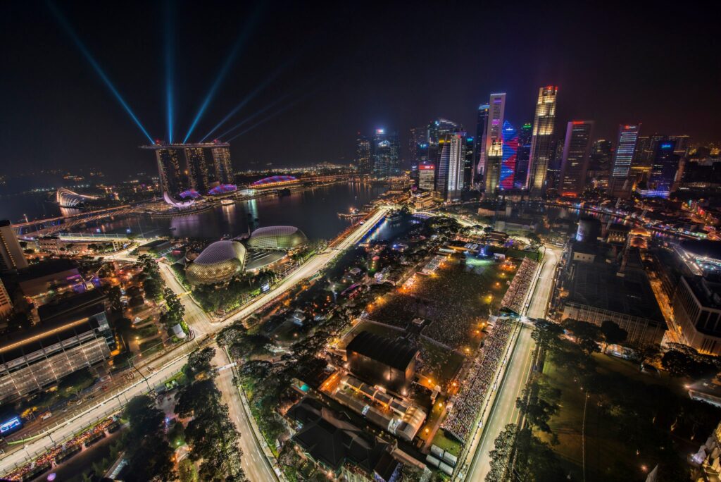 Elevated view of the Singapore Grand Prix and city skyline at night.